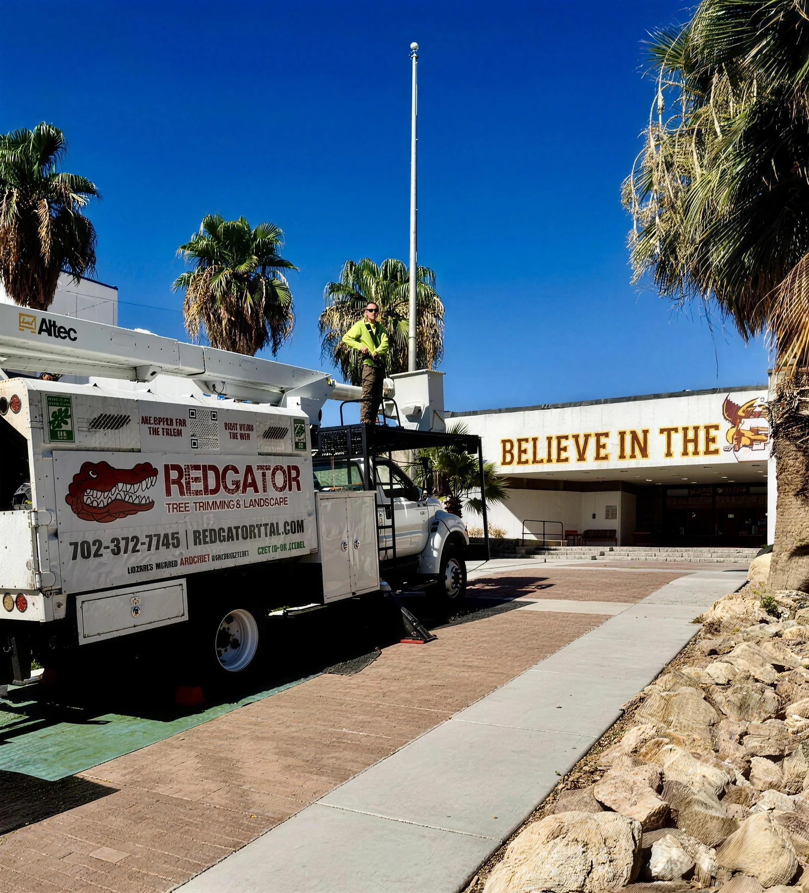 RedGator bucket truck parked at a commercial property with palm trees